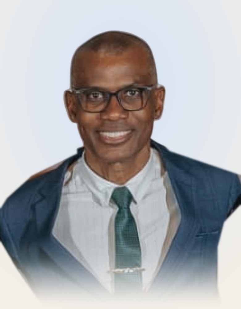 Pastor Wanderly Correa sorrindo, de óculos, terno azul e gravata verde